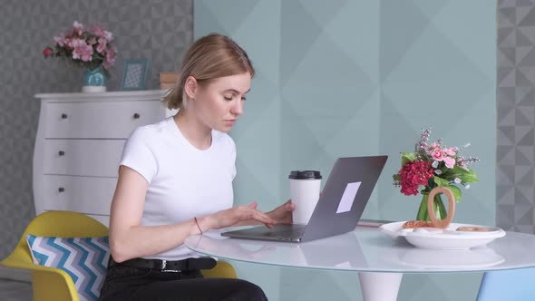 Young Blonde Woman Working at Computer Drinking Coffee, lunch Break time