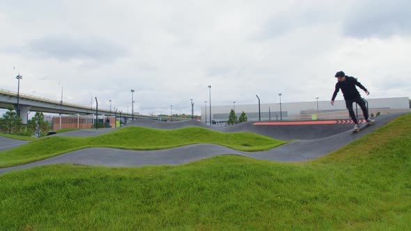 Guy Rides Skateboard on Asphalt Waves alt