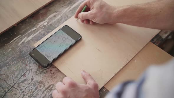 Carpenter Uses Mobile Phone for Drawing Details