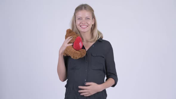 Young Happy Pregnant Businesswoman Hugging Teddy Bear alt