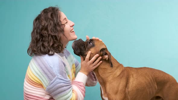 Woman stroking and hugging her boxer dog. Animals and pets concept. alt