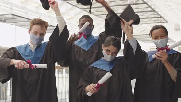 Group of Four Happy Graduates with Diplomas alt