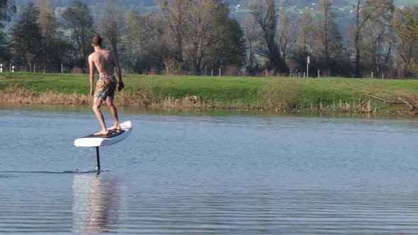 Foilboard elevating above river waters Europe in slow motion alt