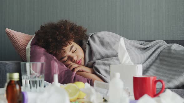 Ill Young African American Girl Is Sleeping Relaxing During Disease Lying on Couch in Apartment alt
