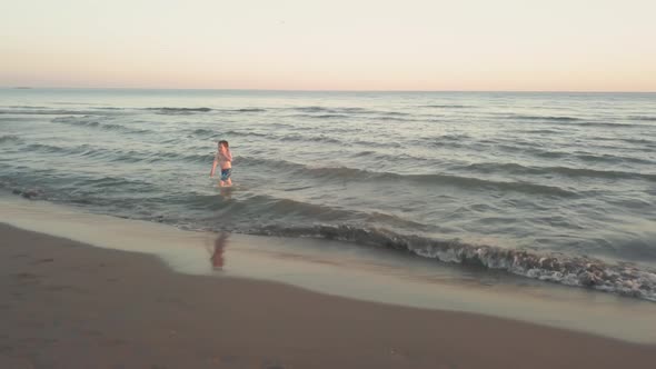 Young Sister and Brother Who Are Playing in the Sea