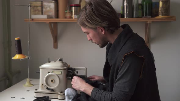 Young Man Tailor Sewing Fur on Furrier Machine