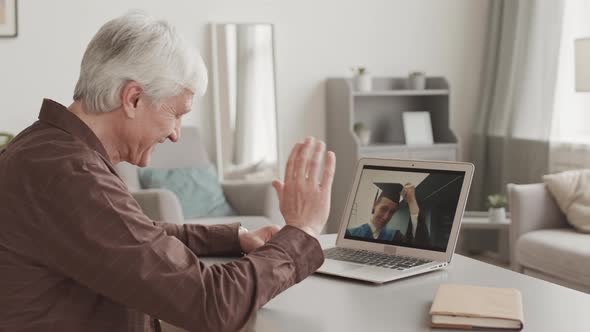 Father Talking to Son during Graduation Ceremony by Internet alt