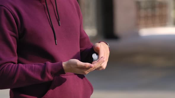 Portrait of Young Man That Sanitizes Alcohol Antiseptic Hands To Protect From the nCov-19 alt