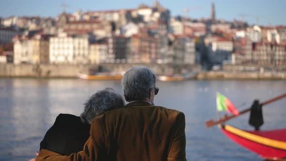 Traveling Family Couple of Old People Sitting at Duero River Quay in Porto