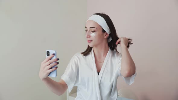 Young Woman with Collagen Pads Under Eyes Records Selfie Video Stoies on Her Phone