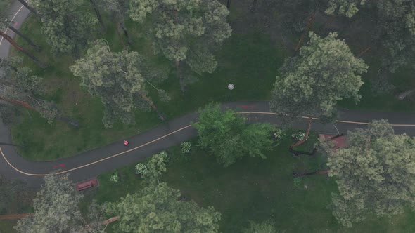 Woman run in empty park on rainy day. Runner training outdoor. Running and sport concept alt