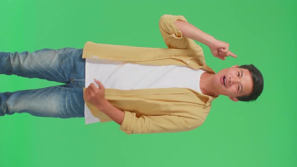 Young Asian Man Thinking About Something Then Raising Her Index Finger In Green Screen Studio alt