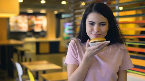 Happy Woman Enjoying Smell of Tasty Burger and Smiling on Camera, Sandwich Club alt