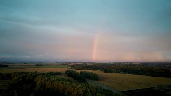 Dark Thunderstorm Clouds and Double Rainbow Over Forest and Wheat Field, Areal Dron Shoot. alt