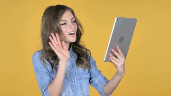 Video Chat By Young Girl Via Tablet Isolated on Yellow Background alt