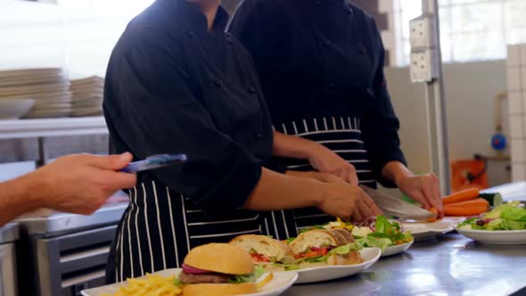 Manager giving order to chef in commercial kitchen 4k alt