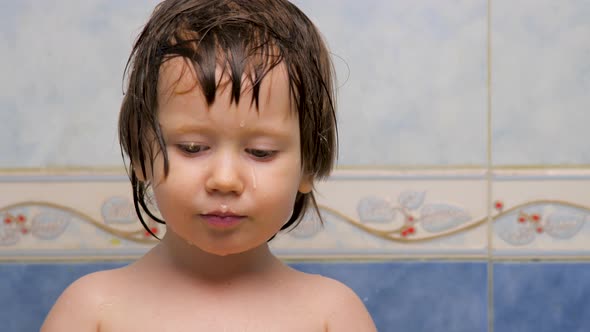 Face Expression Concept. Girl Looking at the Camera. Wet Skin of Kid After a Bath. Pediatrics