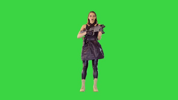 Girl in Black Tank Top and Leather Skirt Stands Holding a Machine Gun on a Green Screen Chroma Key