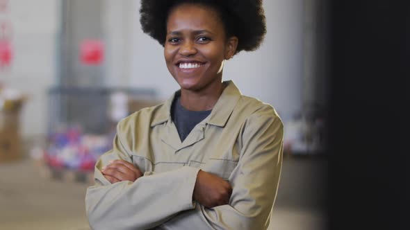 Portrait of african american female worker looking at camera and smiling in warehouse alt