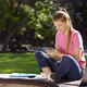 Happy Female Student Texting on Smartphone in Park - VideoHive Item for Sale