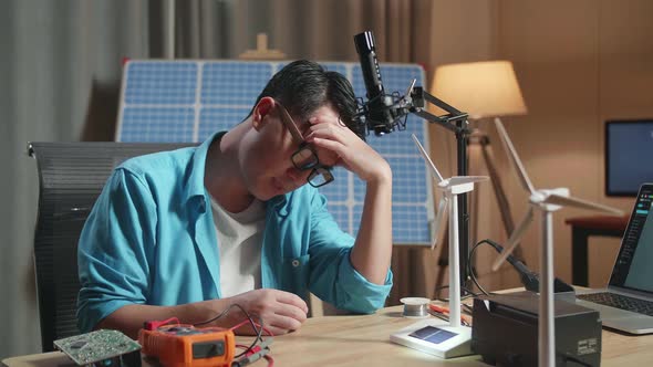Asian Man Upset Failing Testing The Wind Turbine While Working With Laptop Next To The Solar Cell alt