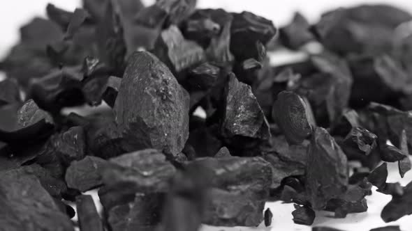 Super Slow Motion Shot of Coal Falling on White Background at 1000 Fps. alt
