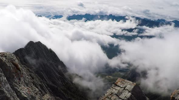 Time lapse of fast moving clouds above a valley surrounded by large mountains. alt