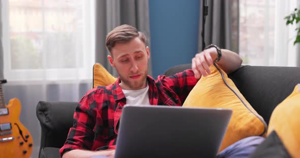 Focused Caucasian Man Using Laptop at Home Looking at Screen Chatting Reading or Writing Email alt
