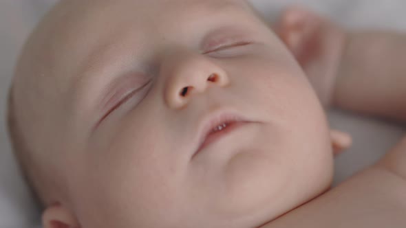 Close Up of Adorable Baby Boy Sleeping Naked in Bed alt