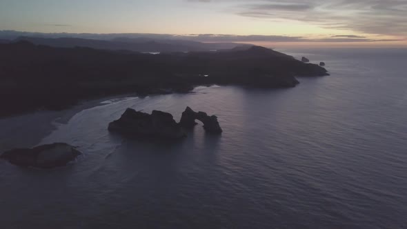 Dark New Zealand coastline during sunset