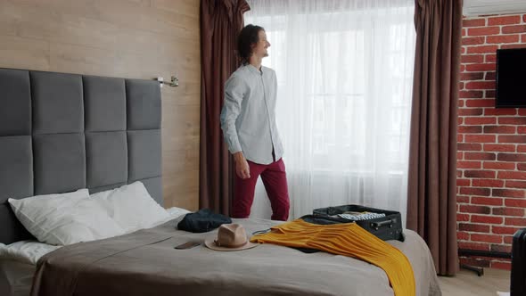 Slow Motion of Guy Unpacking Bag in Hotel Then Kissing and Hugging Beautiful Woman alt