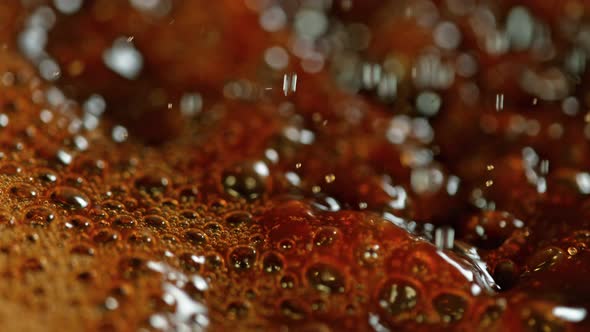 Super Slow Motion Macro Shot of Splashing Fresh Coffee and Water Droplets at 1000 Fps. alt