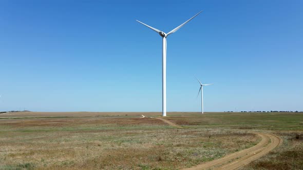 Working Wind Turbines Standing on the Field in Summer
