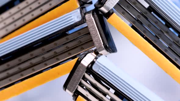 Disposable shaver razor blades rotating on white background, macro shot in 4k. alt