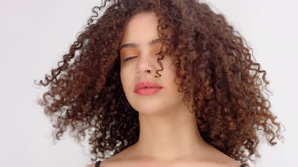 Mixed Race Black Woman with Freckles and Curly Hair Closeup Portrait with Hair Blowing