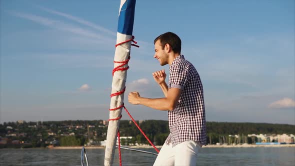 A Young and Charismatic Man Dances and Fools Around on a Yacht During the Day alt