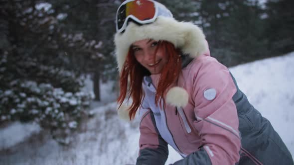 Happy Girl in a Warm Hat and Gloves Makes a Snowball and Throws It Near Camera Active Weekend in the alt