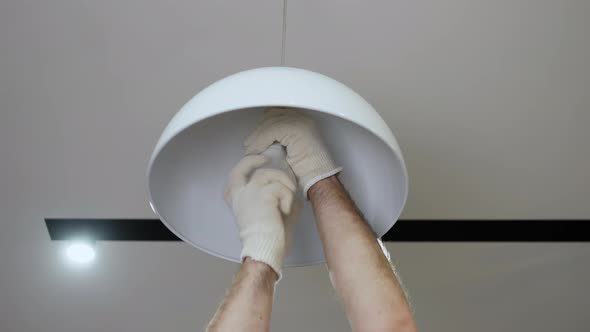 Electrician Turn On The Light On The Pendant Chandelier. Replacing A Burned Out Light Bulb alt