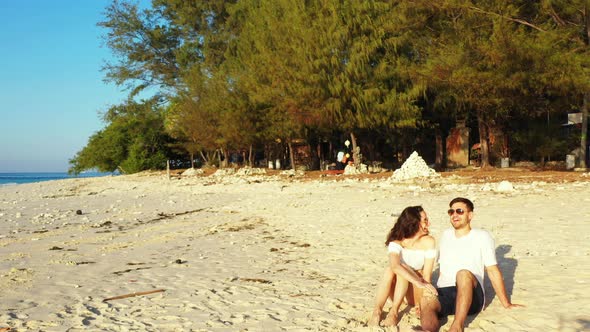 Happy people on honeymoon vacation enjoy luxury on beach on white sand 4K background alt