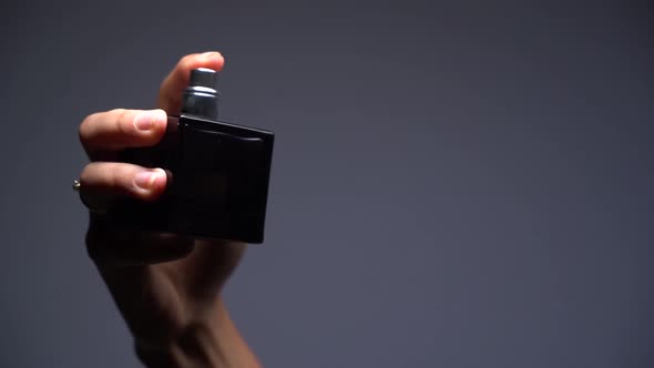 Close-up Slow Motion Silhouette of a Girl Spraying Perfume on Dark Background alt