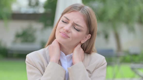 Outdoor Portrait of Young Businesswoman Having Neck Pain alt
