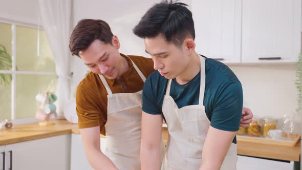 Asian young handsome LGBTQ male gay family couple enjoy bake bakery foods in kitchen at home. alt