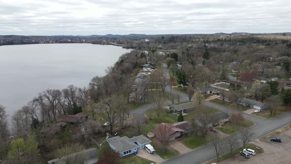 Aerial view of Menomonie Lake on a gray day in autumn. Residential neighborhood on edge of lake.