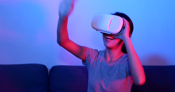 Woman play with VR device with purple and blue light alt
