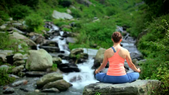 Woman Meditating at Tropical Waterfall alt