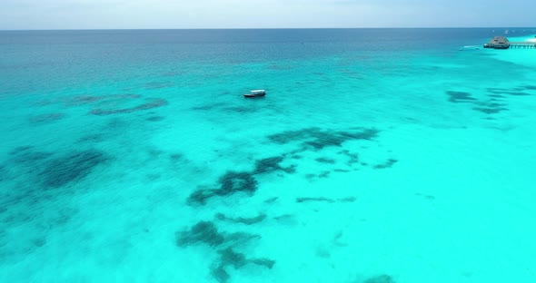 Aerial view of the fishing boat in clear blue water at sunny day in summer