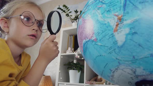 Child with Globe and Magnifying Glass