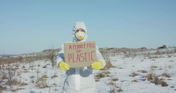 Portrait of Man Wore in Cover Suit Shows Protest Sign a Planet Full of Plastic alt