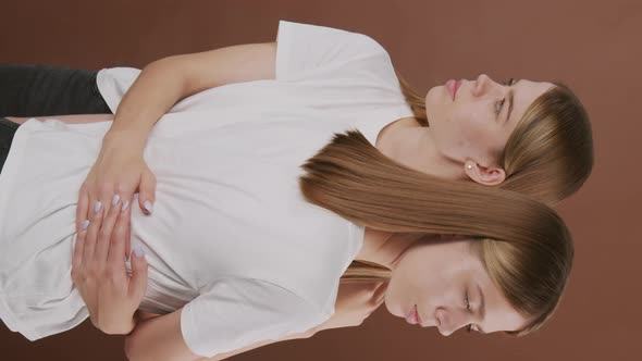 Vertical Portrait of Twin Sisters Embracing alt
