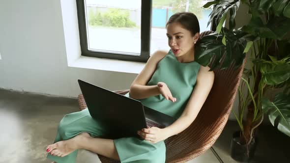Young American Woman is Having Online Talk and Using Laptop at Home Room Iroi alt